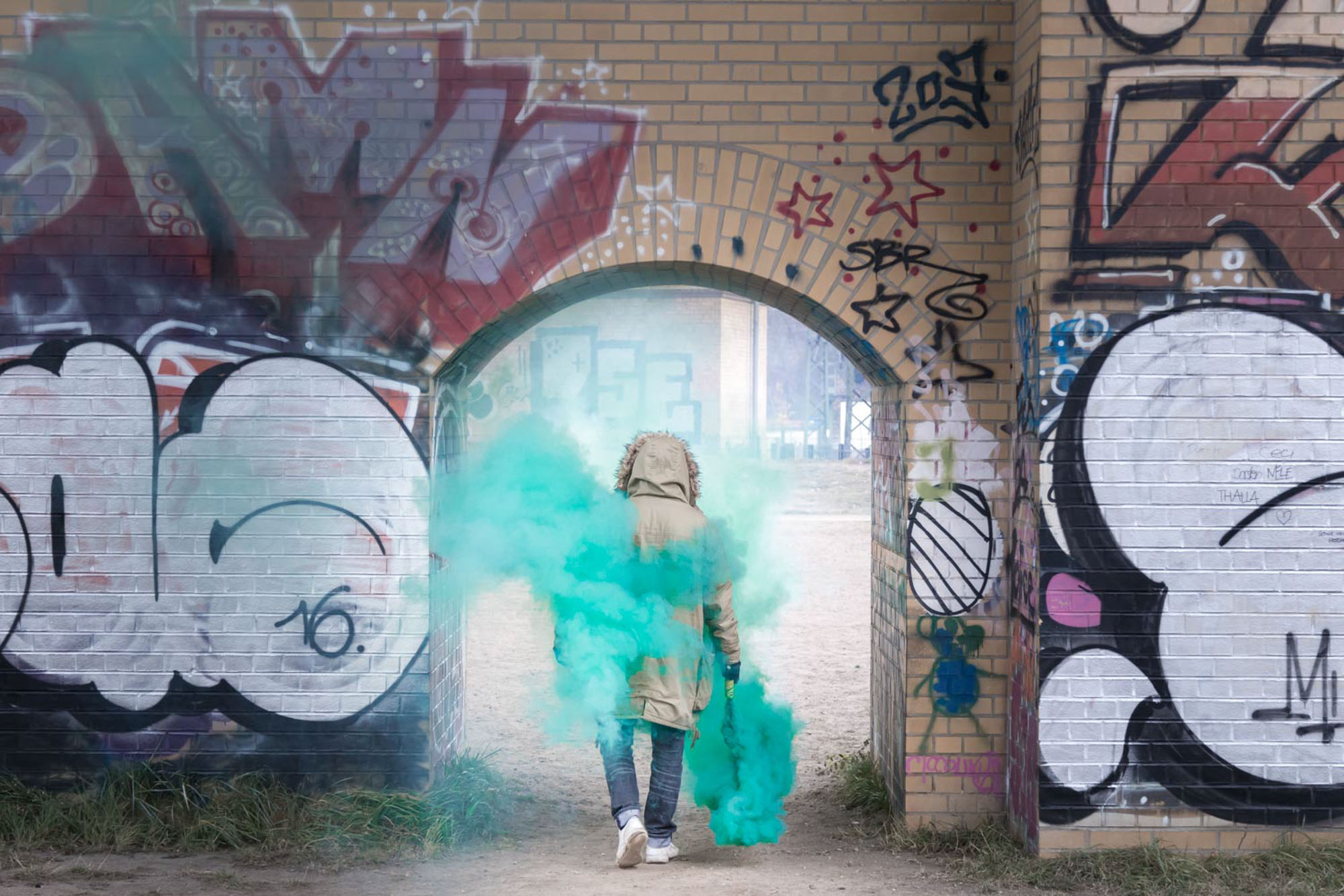 Person in Jacke läuft mich Rauchfackel durch Bogen