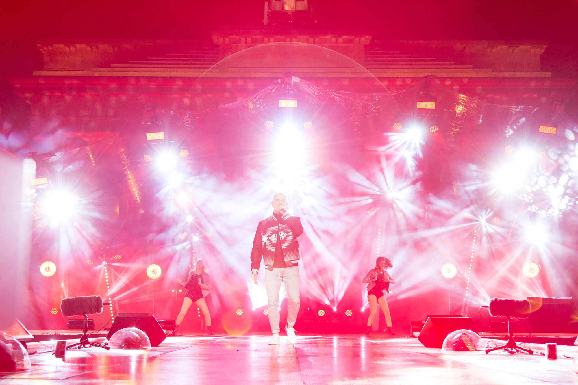 Oli P. in rotem Licht auf der Bühne vor dem Brandenburger Tor
