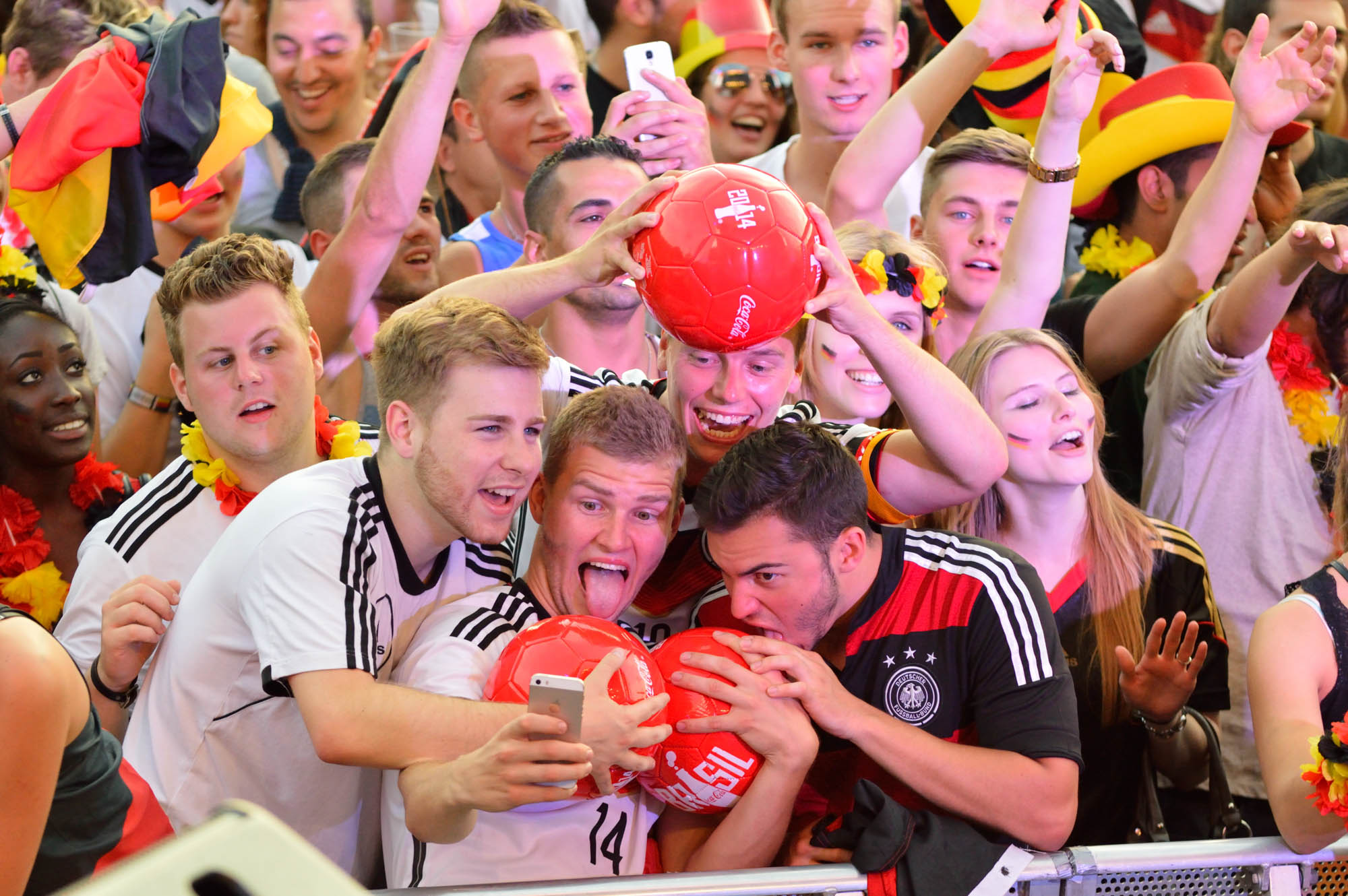 Gruppe macht Foto von sich und einem Ball auf der Fanmeile in Berlin 2014